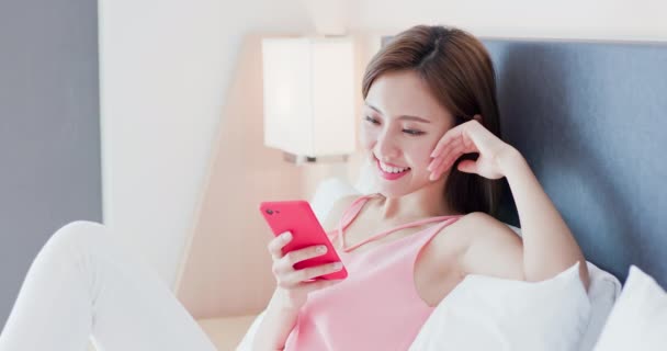 Азиатка с радостью пользуется смартфоном — стоковое видео