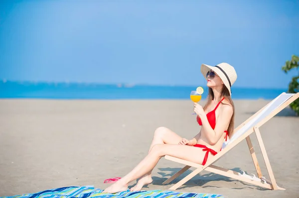 Woman sunbathing with juice — Stock Photo, Image