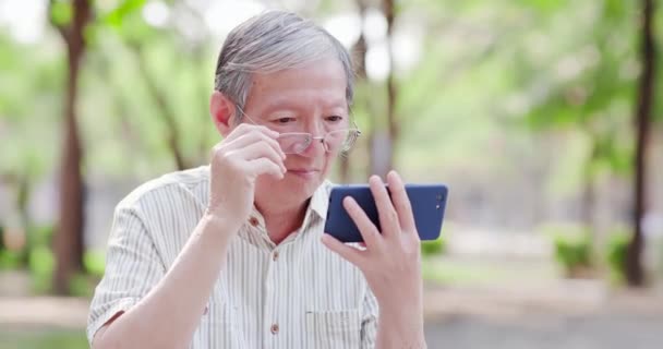 Yaşlı adam cep telefonu ile video izlemek — Stok video