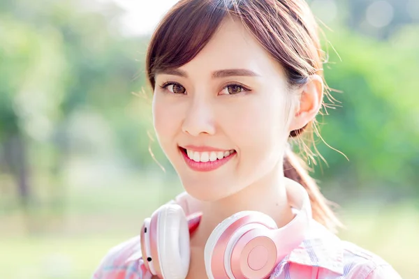 Junge asiatische Frau lächelt Sie an — Stockfoto