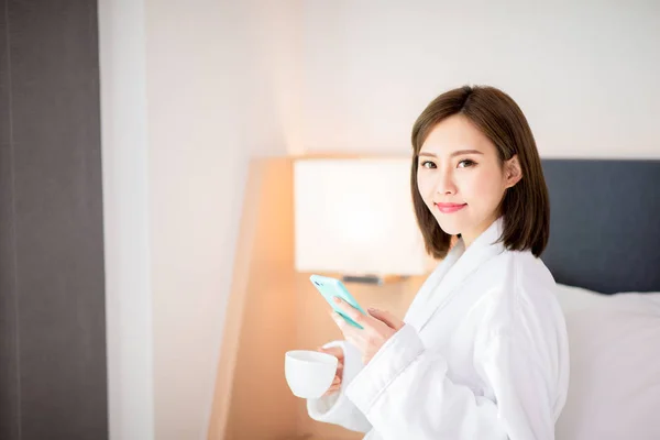 Mulher usar smartphone com café — Fotografia de Stock