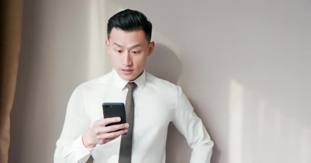 Азиатский бизнесмен пользуется мобильным телефоном — стоковое видео