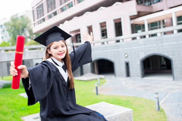 Menina gratuate elevador braço feliz — Fotografia de Stock