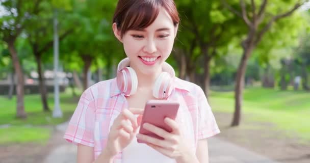 Молодая азиатка пользуется телефоном — стоковое видео