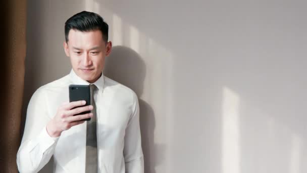 Азиатский бизнесмен пользуется мобильным телефоном — стоковое видео