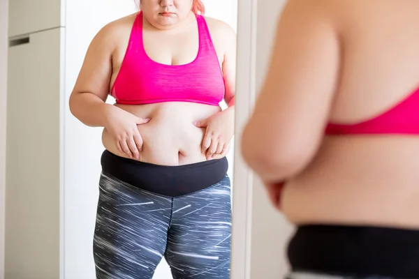 Plus size girl pinch her waist — Stock Photo, Image