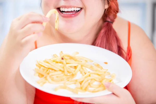 Žena jíst smažené hranolky — Stock fotografie
