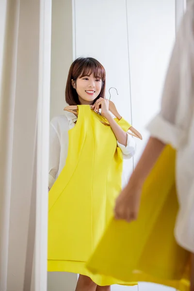 Asian girl trying dress happily — Stock Photo, Image