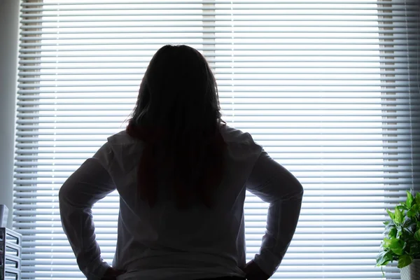 Woman looking out of office — Stock Photo, Image