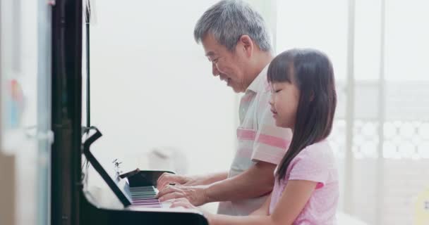 Grandpa teach girl play piano — Stock Video