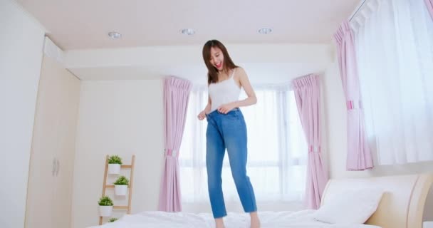 Jeune femme sauter sur le lit — Video