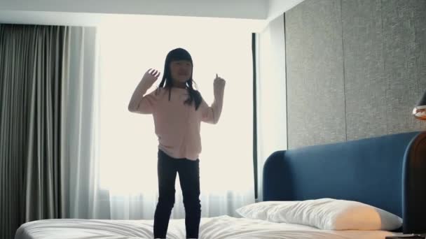 Menina saltar em cima da cama — Vídeo de Stock