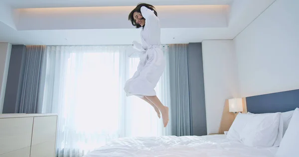 Возбужденная женщина прыгает в халате — стоковое фото