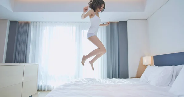 若い女性はベッドの上でジャンプ — ストック写真