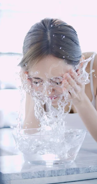 Güzel kadın yüzünü yıkar. — Stok fotoğraf