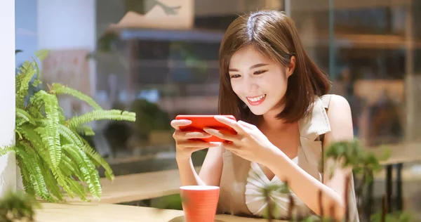 Young woman play mobile game