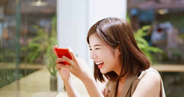 Young woman play mobile game