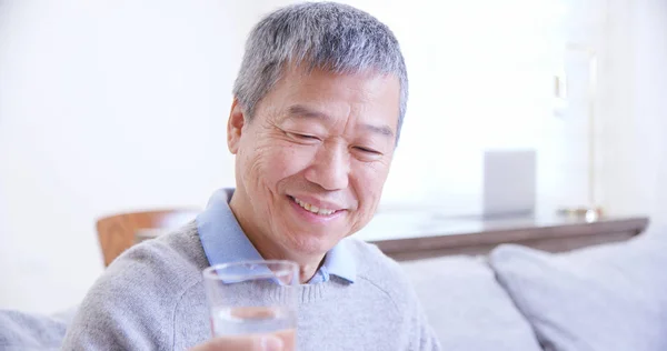 Alter asiatischer Mann trinkt Wasser — Stockfoto