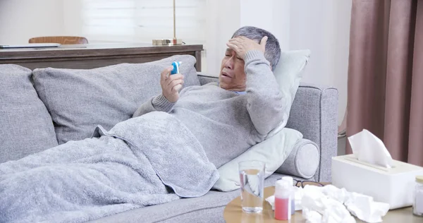 Азиатский пожилой человек имеет температуру — стоковое фото