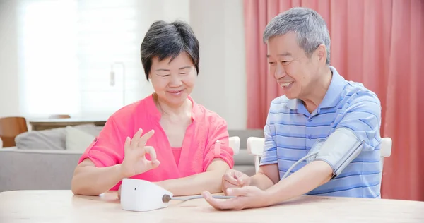 Älteres Ehepaar benutzt Blutdruckmessgerät — Stockfoto