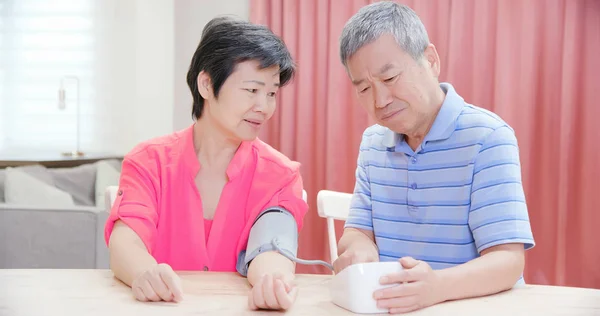 Älteres Ehepaar benutzt Blutdruckmessgerät — Stockfoto
