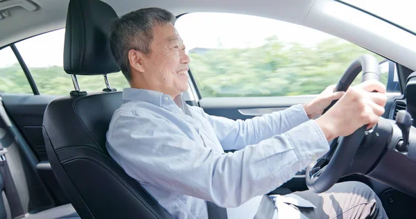 Азиатский пожилой человек за рулем автомобиля — стоковое фото