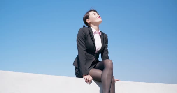 Mujer sentarse en la pared — Vídeos de Stock