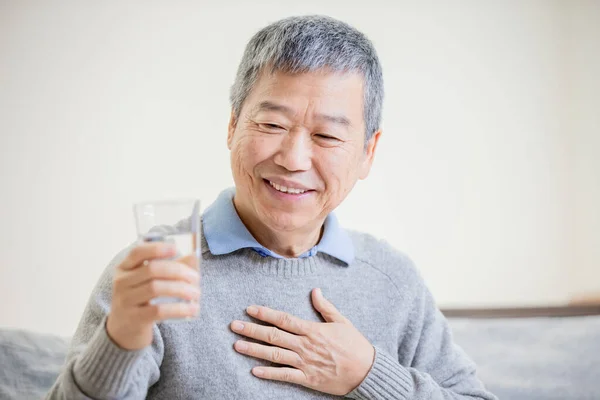 Oude Aziatische man drinken water — Stockfoto