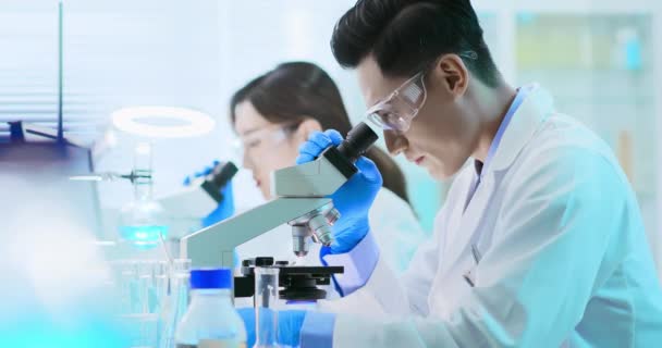 Asian scientist use microscope — Stock Video