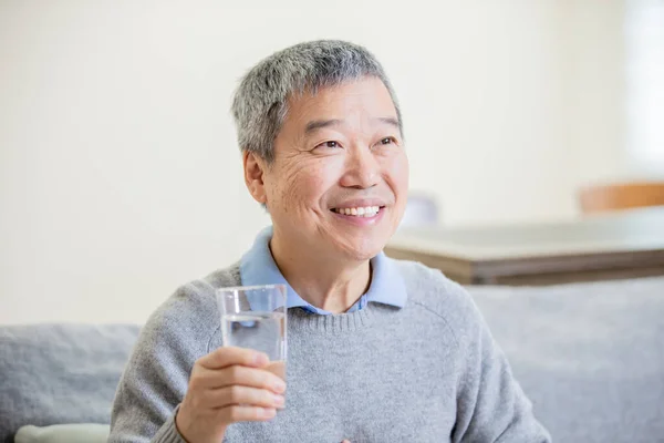 Alter asiatischer Mann trinkt Wasser — Stockfoto