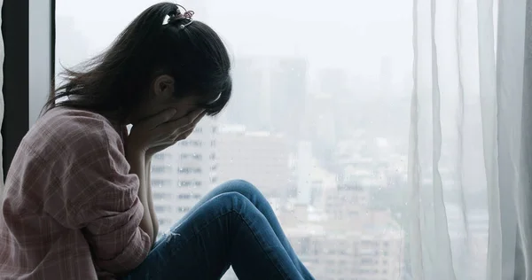 Vrouw huilen in de buurt van venster — Stockfoto