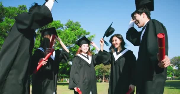 Grupo feliz graduados tirar gorras — Vídeo de stock