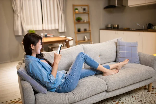 Asiatische Junge Frau Benutzt Smartphone Und Liegt Gemütlich Auf Couch — Stockfoto