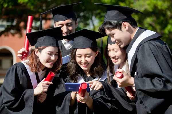 Grupo Feliz Graduados Estudiantes Utilizan Teléfono Móvil Para Mirar Fotos —  Fotos de Stock