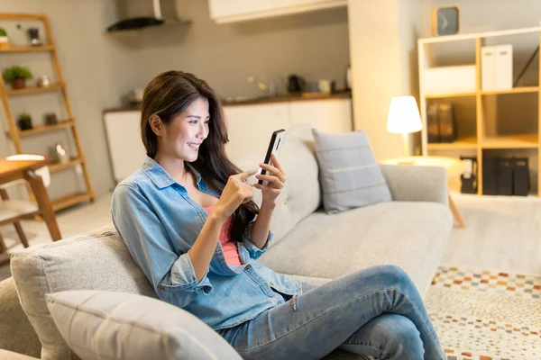 Aasialainen Nainen Käyttää Älypuhelinta Onnellisesti Kotona — kuvapankkivalokuva