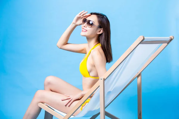Sommersolkrem Reisekonsept Asenisk Bikinijente Som Ligger Strandstol Med Håndflate Solskinn – stockfoto