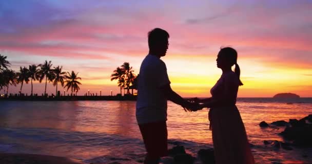 Ζευγάρι σταθεί στο ηλιοβασίλεμα παραλία — Αρχείο Βίντεο