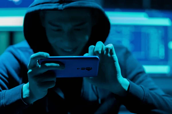 亚洲男性黑客使用手机窃取手机游戏的特写镜头 — 图库照片