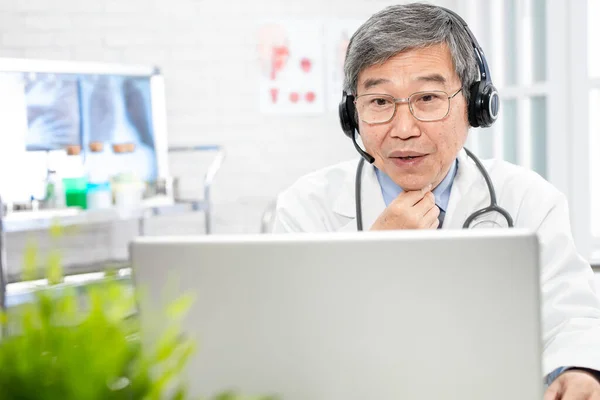 Telelääketieteen Käsite Aasialainen Vanhempi Mieslääkäri Puhuu Kurkkukipu Oire Potilaalle Internetissä — kuvapankkivalokuva
