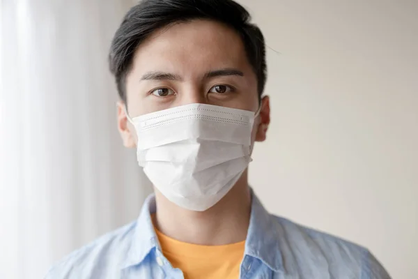 asian young man with face mask stay isolation at home for self quarantine due to an epidemic of COVID-19