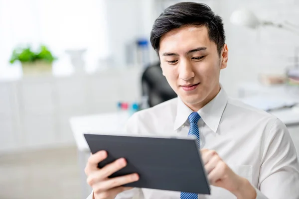 Asiatisk Ung Forretningsmann Leser Nyheter Nettbrett Kontoret – stockfoto