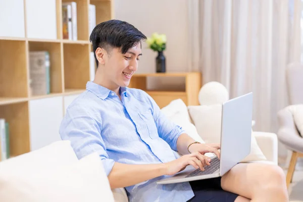 Asiatisk Ung Mann Sitter Sofaen Bruker Laptop Fritidsaktig Hjemme – stockfoto