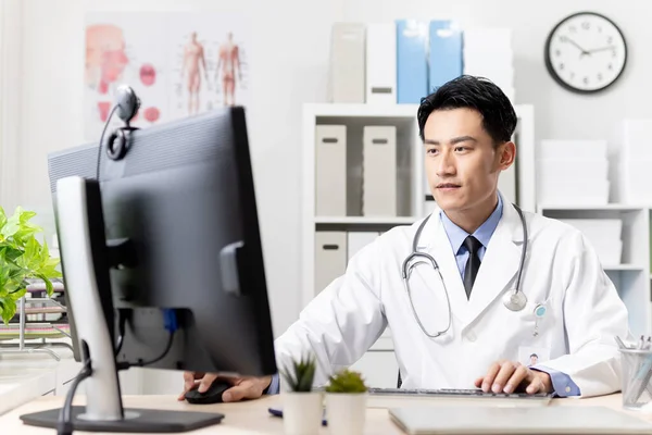 Asiatisk Ung Läkare Arbete Och Skriva Något Datorn Kliniken — Stockfoto
