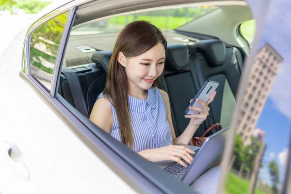 Aasialainen Menestyvä Liiketoiminnan Nainen Työskentelee Autossa Käyttämällä Älypuhelinta Kannettavaa Tietokonetta — kuvapankkivalokuva