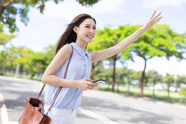 亚洲女商人在路上打了个出租车去上班 — 图库照片