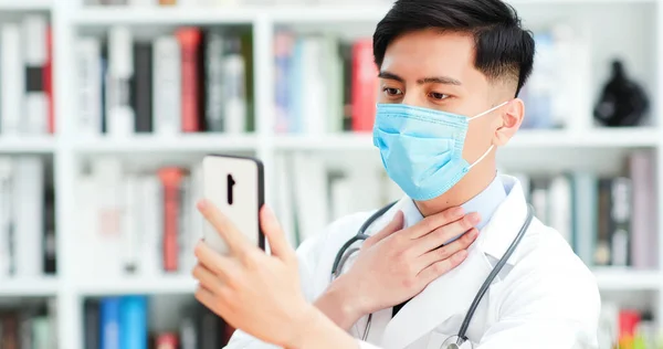 テレメディシンの概念 アジアの男性医師の閉鎖は 携帯電話でビデオチャットで病気について患者に説明します — ストック写真