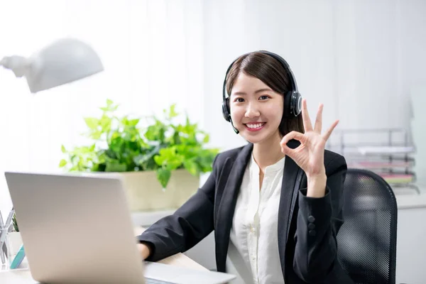 远程办公的概念 在办公室里 亚洲女商人头戴耳机 对着你微笑 摆出一副不错的姿势 — 图库照片