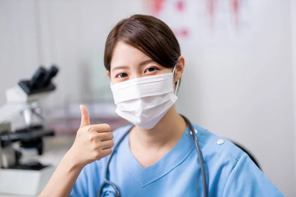 Ameliyat Maskesi Takan Asyalı Genç Bayan Doktor Klinikte Başparmağıyla Sana — Stok fotoğraf