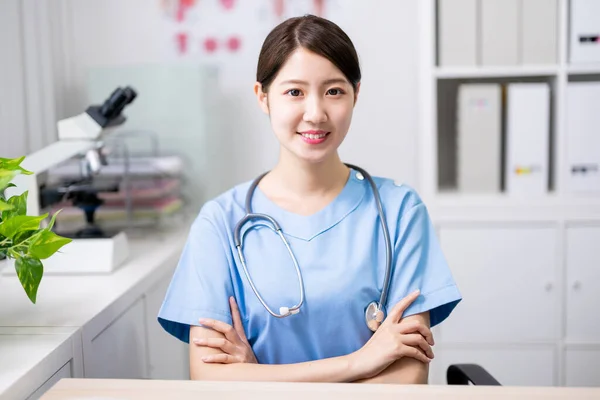 Asiático Joven Médico Sonrisa Usted Con Cruz Brazo Clínica —  Fotos de Stock