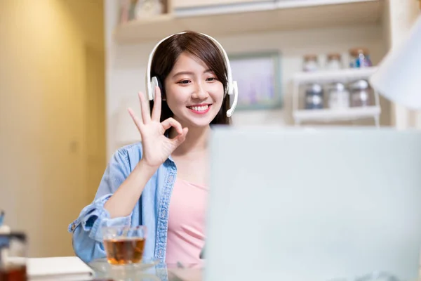 远程办公的概念 带着耳机的亚洲女商人在家里用手提电脑与同事们进行视频会面 — 图库照片